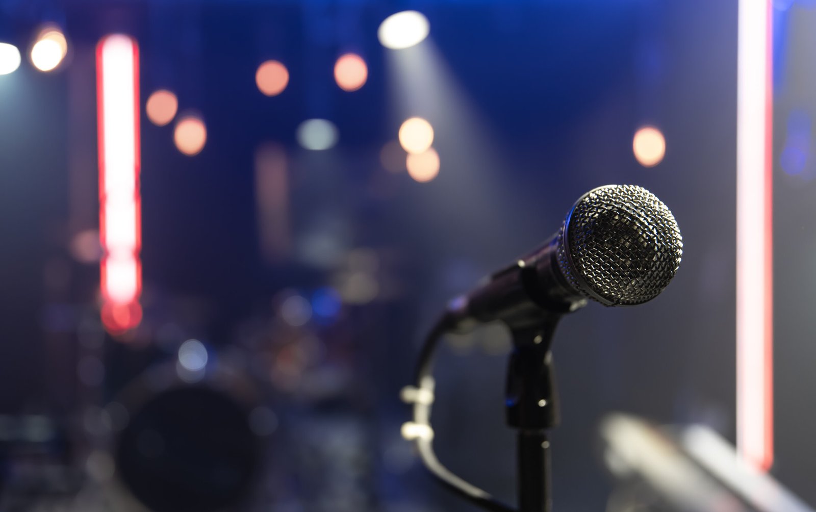 Close up microphone on blurred background with bokeh. Close up of a microphone on a concert stage with beautiful lighting.